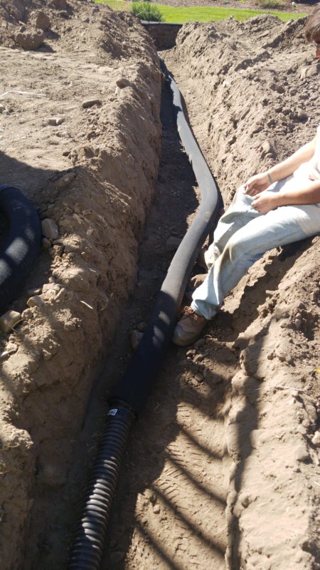 Installation of drainage pipes in trench for stormwater management