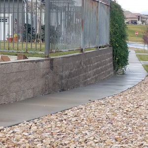 Dry-stack-block-wall-filled-with-concrete-small-block-retaining-wall-wrought-iron-fence-Saratoga-Springs-Utah